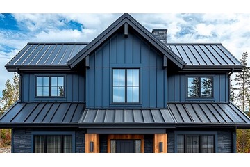 Person using a soft brush to clean metal siding panels on a house exterior